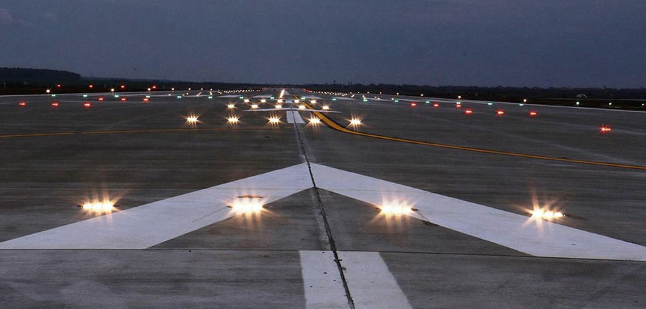 Fotos: Nahaufnahme einer Landebahn bei Nacht mit leuchtenden Bodenlichtern und weißen Markierungen